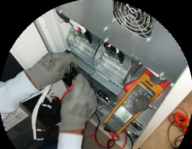 Technician with insulated gloves measuring in a panel