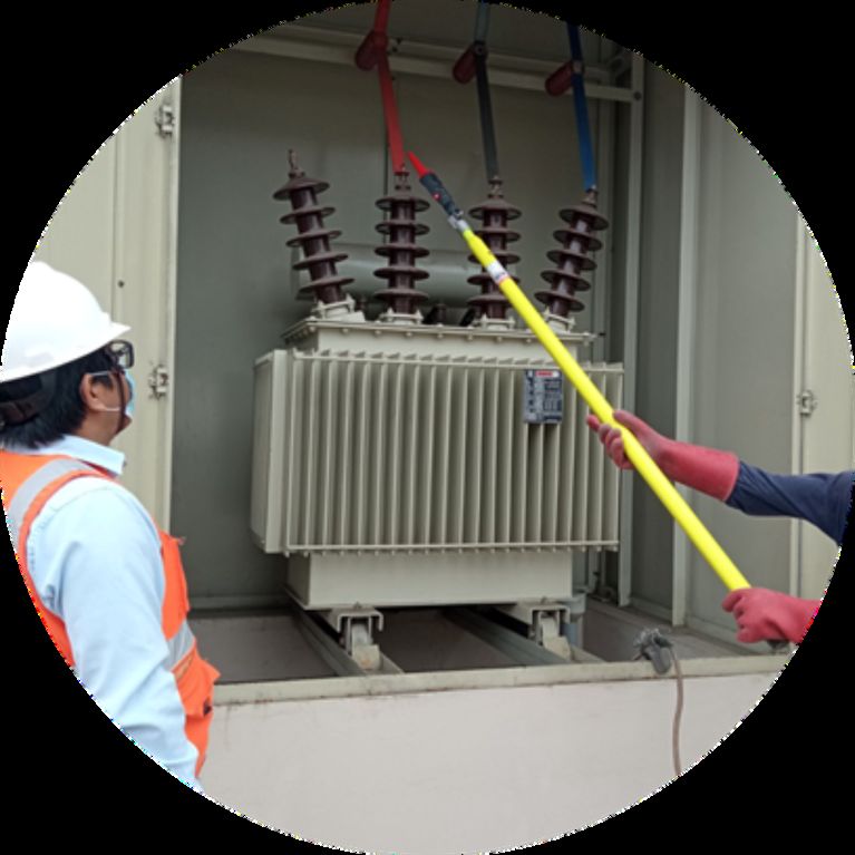 Technician working on a distribution transformer with an insulated hot stick